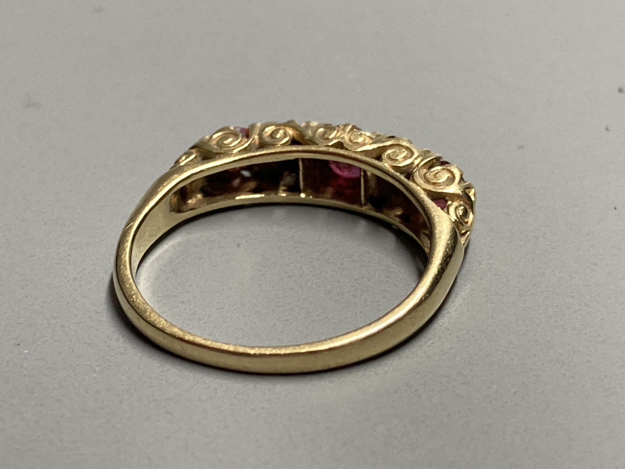 An 18ct Victorian style two stone diamond and three stone ruby set half hoop ring, size K/L. gross 3.1 grams.